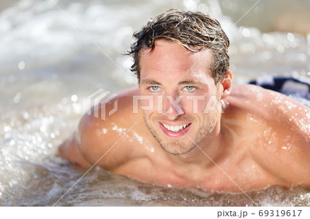 Beach man having fun in water smiling happy. Portrait of young handsome male beach model surfing on bodyboard Beach man having fun in water smiling happy. Portrait of young handsome male beach model surfing on bodyboard 69319617