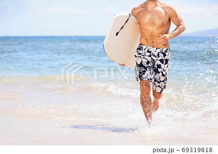 Beach fun surfer man running with body board. Fit fitness model doing water sport bodyboarding surfing. Photo from Kaanapali beach, Maui, Hawaii Beach fun surfer man running with body board. Fit fitness model doing water sport bodyboarding surfing. Photo from Kaanapali beach, Maui, Hawaii 69319618
