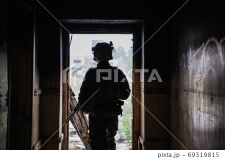 Front view close up of caucasian soldier with a rifle stand guard securing territory looking around. Front view close up of caucasian soldier with a rifle stand guard securing territory looking around. 69319815