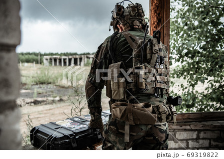 The soldier pulls a rifle out of the ammunition case and insert ammunition clip into assault rifle The soldier pulls a rifle out of the ammunition case and insert ammunition clip into assault rifle 69319822