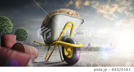 Wheelbarrow full of sand in city. Yellow wheelbarrow on single wheel 69320161