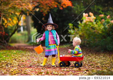 Kids trick or treat on Halloween night. 69321014