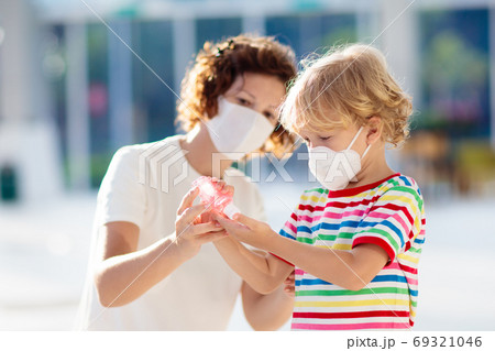 Mother and child with face mask and hand sanitizer 69321046
