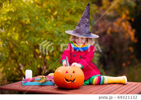 Kids carving Halloween pumpkin. Kids carving Halloween pumpkin. 69321132