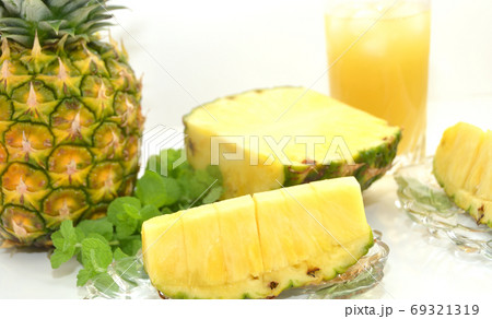 葉付きパイナップルとカットのパイナップルとパイナップルジュース 69321319