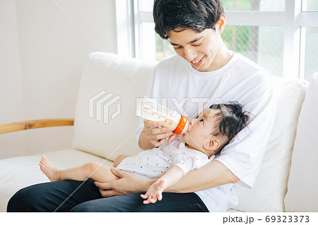 赤ちゃんにミルクをあげるお父さん 69323373