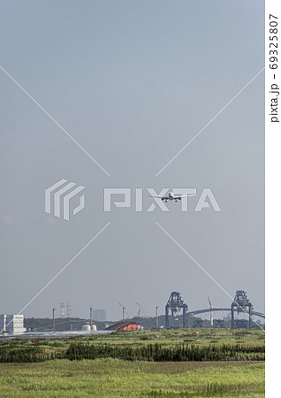 陽炎 かげろう が立ち昇る羽田空港の真夏の滑走路に着陸してくる旅客機の写真素材
