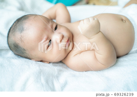 Adoraable infant baby boy lying on white blanket Adoraable infant baby boy lying on white blanket 69326239