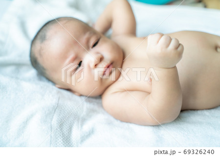 Adoraable infant baby boy lying on white blanket 69326240