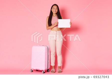 Travelling, holidays and vacation concept. Full-length of asian cute exchange student arrive at country with suitcase, holding piece of paper and smiling, searching for host-family in airport Travelling, holidays and vacation concept. Full-length of asian cute exchange student arrive at country with suitcase, holding piece of paper and smiling, searching for host-family in airport 69327043