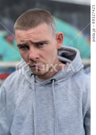 A bully guy in a light sports jacket with a hood 69327425