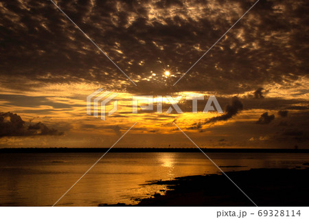 沖縄県久米島の空港近くビーチしんり浜ビーチの夕日、オレンジ色の夕焼けトワイライト風景写真 沖縄県久米島の空港近くビーチしんり浜ビーチの夕日、オレンジ色の夕焼けトワイライト風景写真 69328114