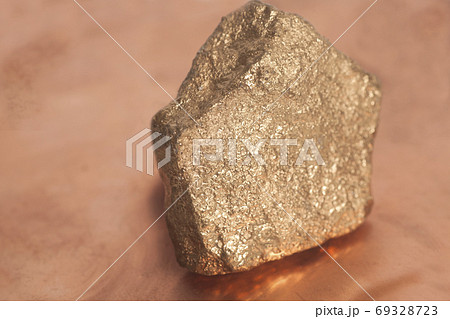 Golden nugget on copper background 69328723