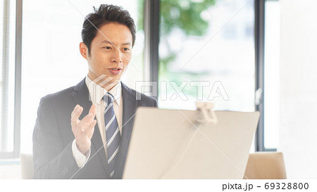 PCに向かってビデオ通話をしている男性 PCに向かってビデオ通話をしている男性 69328800
