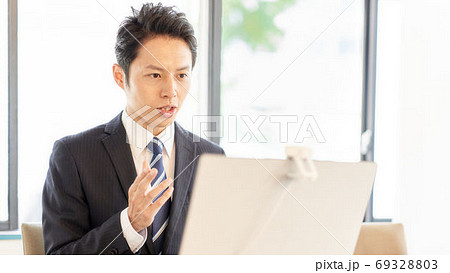 PCに向かってビデオ通話をしている男性 69328803
