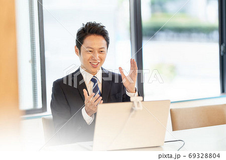 PCに向かってビデオ通話をしているスーツの男 PCに向かってビデオ通話をしているスーツの男 69328804