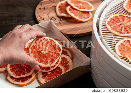 Packing dried grapefruit into box Packing dried grapefruit into box 69328929