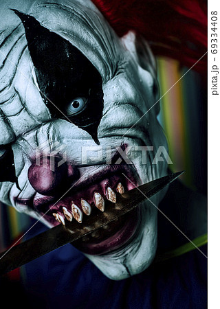scary evil clown with a big knife in his mouth scary evil clown with a big knife in his mouth 69334408