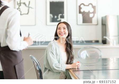 カフェで注文をする若い女性と店員 69337152