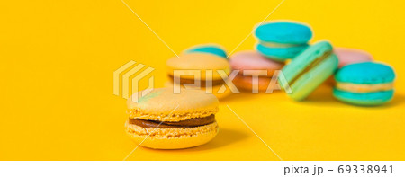 Sweet almond colorful unicorn pink blue yellow green macaron or macaroon dessert cake isolated on trendy yellow modern fashion background. French sweet cookie. Minimal food bakery concept Copy space Sweet almond colorful unicorn pink blue yellow green macaron or macaroon dessert cake isolated on trendy yellow modern fashion background. French sweet cookie. Minimal food bakery concept Copy space 69338941