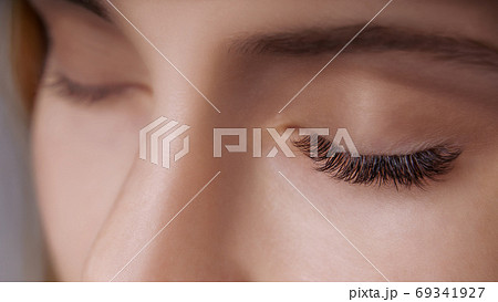 Eyelash Extension Procedure. Woman Eye with Long Eyelashes. Close up, selective focus. Eyelash Extension Procedure. Woman Eye with Long Eyelashes. Close up, selective focus. 69341927