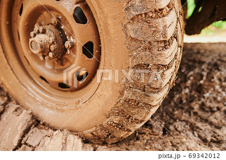 Wheel closeup in a countryside landscape with a muddy road. Wheel closeup in a countryside landscape with a muddy road. 69342012