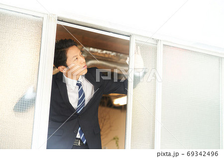 窓を開けて換気をする男性 69342496