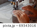 A woman sews on an industrial flat-seam sewing machine. Soft focus 69343016