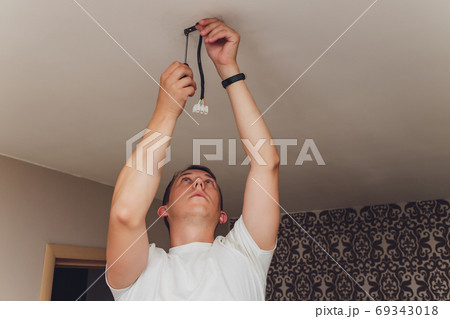 an electrician. repair work. Chandelier to hang on the ceiling. an electrician. repair work. Chandelier to hang on the ceiling. 69343018