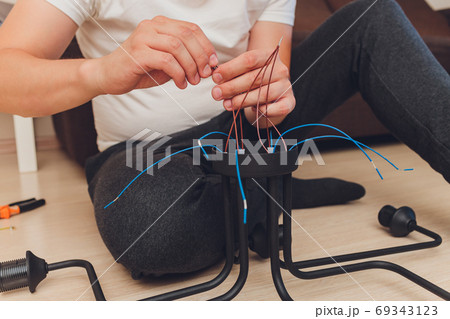 Chandelier with wires and tools on the floor, preparation to installation. Chandelier with wires and tools on the floor, preparation to installation. 69343123