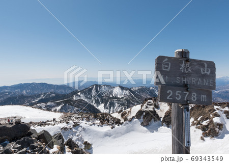 群馬県と栃木県の境目にある日本百名山の冬期日光白根（奥白根山）の山頂の標識と青空 69343549