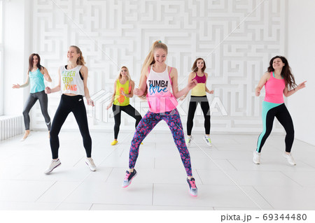 Young women in sportswear at Zumba dance fitness class 69344480