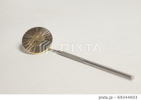 Bitcoin in a dental mirror 69344603