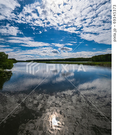 Summer plain lake with sunshine and clouds reflections Summer plain lake with sunshine and clouds reflections 69345373