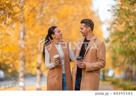 Happy family walking in autumn park on sunny fall day Happy family walking in autumn park on sunny fall day 69345593