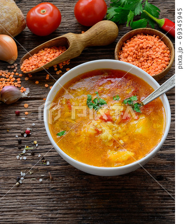 Red lentil soup on the rustic wooden table. Vertical image 69345945