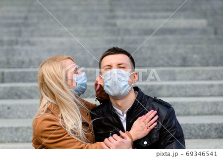 Young couple in love in protective medical mask on face outdoor at street. 69346541