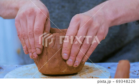 Professional male potter making ceramic jug 69348226