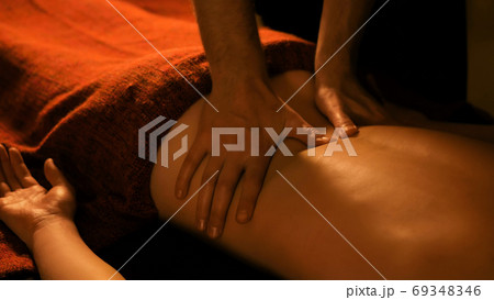 Masseur doing back massage for female client in spa center 69348346