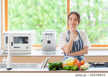 キッチンで考え事をする女性 69348803