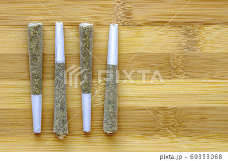 Several Legal Canadian Pre-Rolls Cannabis Joints on a wooden surface. Several Legal Canadian Pre-Rolls Cannabis Joints on a wooden surface. 69353068
