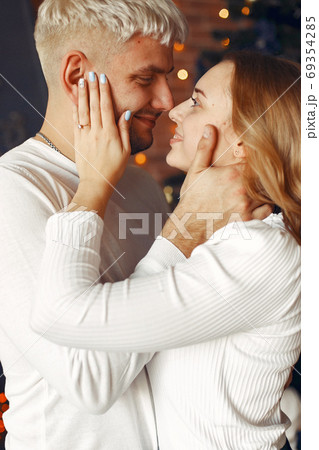 Elegant couple standing at home near christmas tree Elegant couple standing at home near christmas tree 69354285