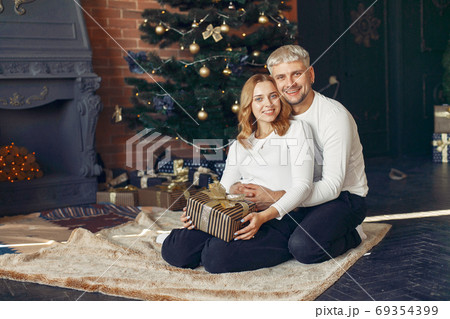Elegant couple sitting at home near christmas tree 69354399