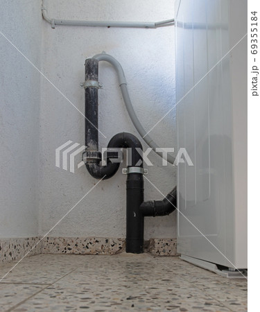 Black siphon behind a washing machine 69355184