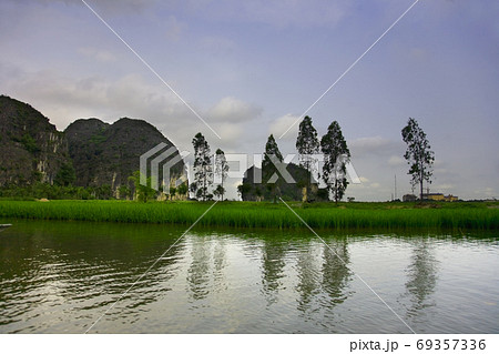 Travelling along rice fields on Tam Coc stream, Ninnh Binh, Viet 69357336