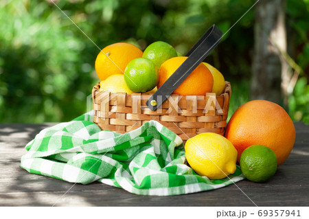 Variuos citrus fruits in basket on garden table 69357941