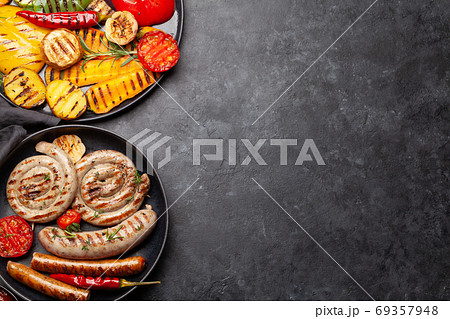 Grilled sausages and vegetables with spices and herbs Grilled sausages and vegetables with spices and herbs 69357948