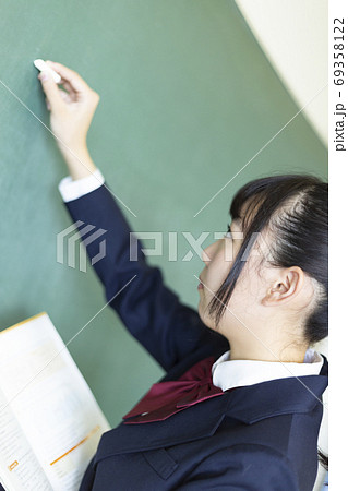 黒板に書く女子高生の写真素材