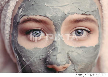 Macro shot woman face with clay facial mask on face isolated, clos up, macro Macro shot woman face with clay facial mask on face isolated, clos up, macro 69358859