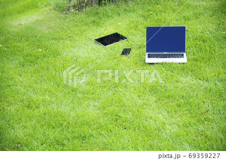 芝生の上のパソコン、タブレットPC、スマートフォン 芝生の上のパソコン、タブレットPC、スマートフォン 69359227